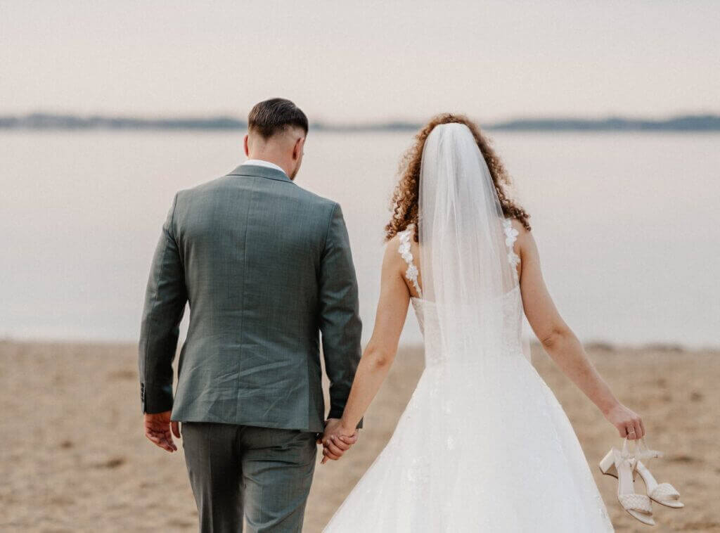 Romantischer Moment am See – Brautpaar von hinten