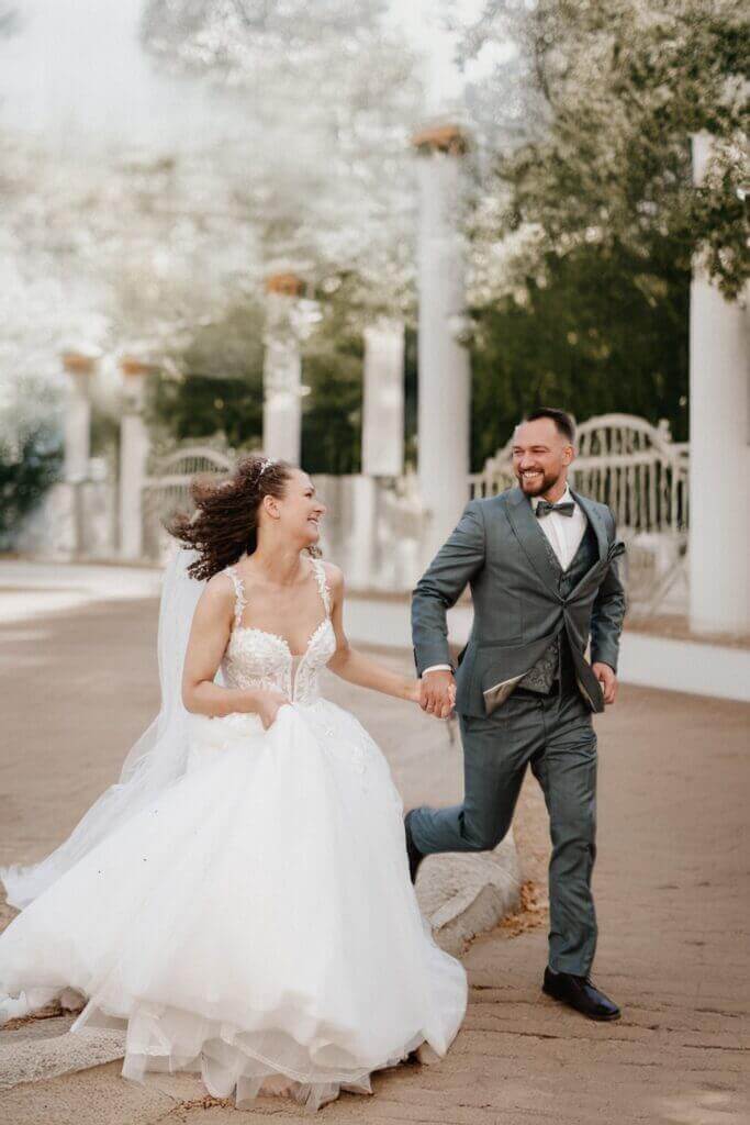 Romantischer Spaziergang – Brautpaar unter Torbogen