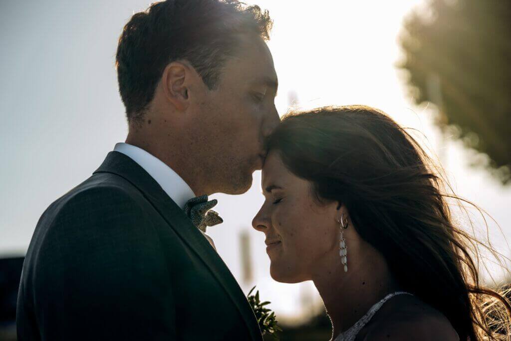 Romantisches Brautpaar auf dem Feld bei Sonnenuntergang