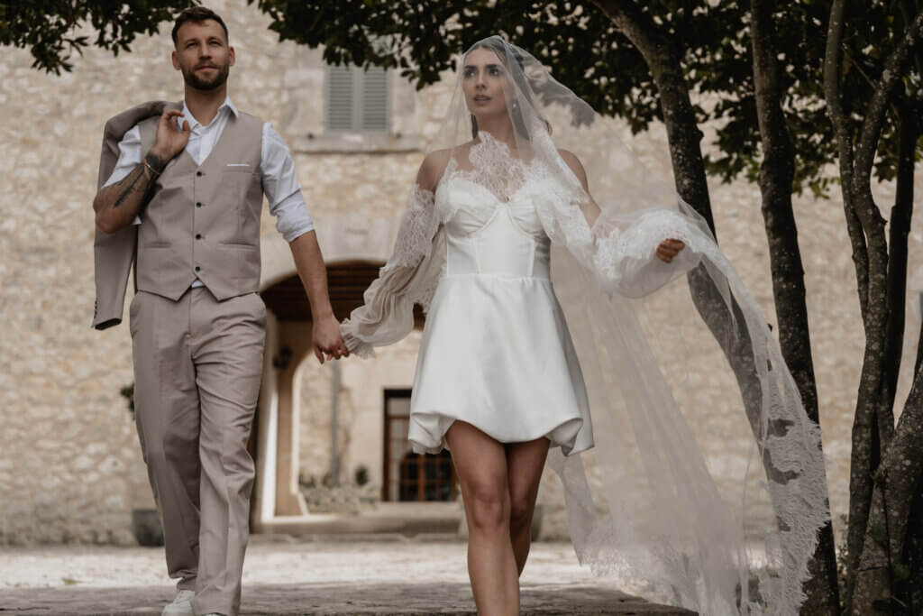 Brautpaar geht mit Schleier